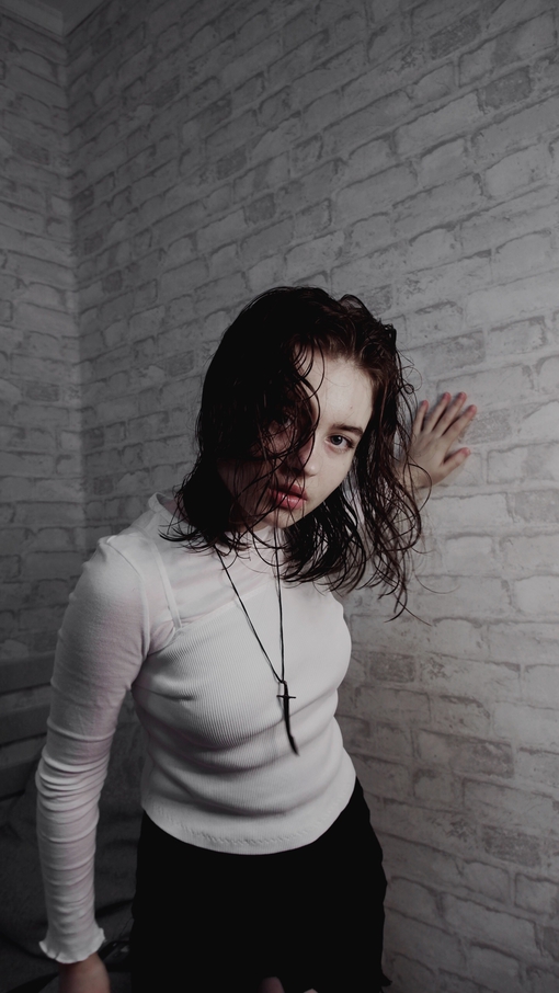 Maya Clars, white, grey, bricks, white bricks, music, song, Spotify photo, ideas for photos, photo ideas, white wall, white clothes, brown hair, sword necklace, new singer, music 2022, musicians 