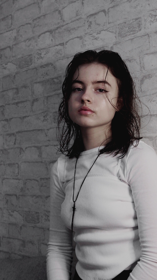 Maya Clars, white, grey, bricks, white bricks, music, song, Spotify photo, ideas for photos, photo ideas, white wall, white clothes, brown hair, sword necklace, new singer, music 2022, singing, YouTube 